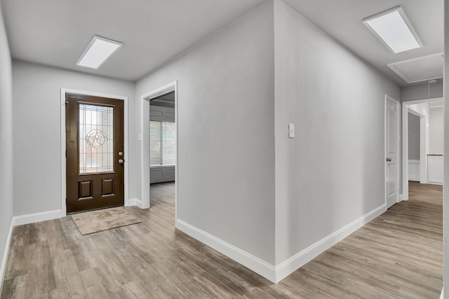 foyer with light wood finished floors and baseboards