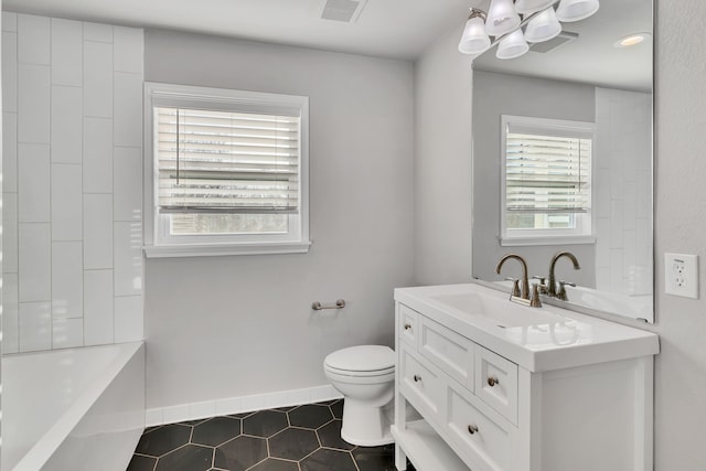 bathroom with vanity, baseboards, visible vents, toilet, and a chandelier