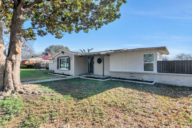 single story home with brick siding, a front lawn, and fence