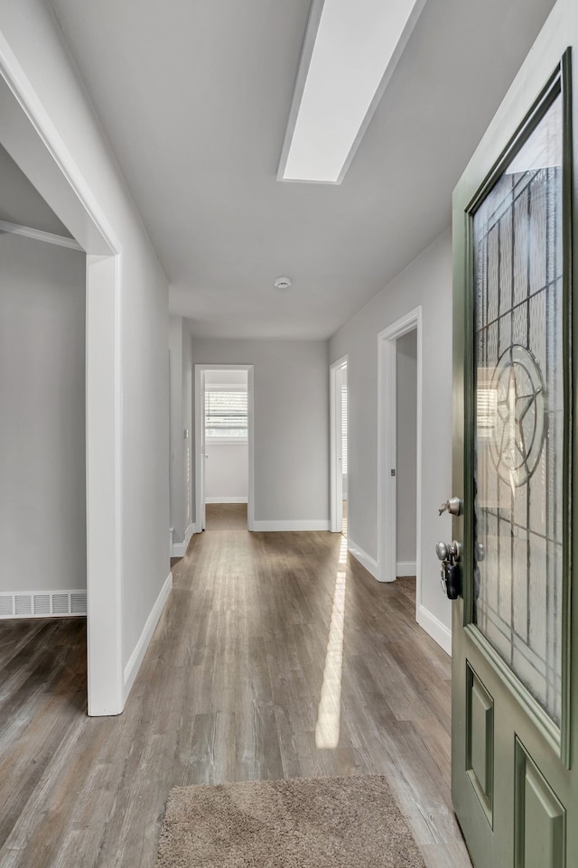 foyer entrance with visible vents, baseboards, and wood finished floors