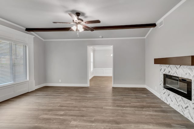 unfurnished living room with ornamental molding, a ceiling fan, and wood finished floors