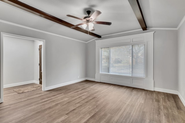 spare room featuring wood finished floors, baseboards, lofted ceiling with beams, ornamental molding, and ceiling fan