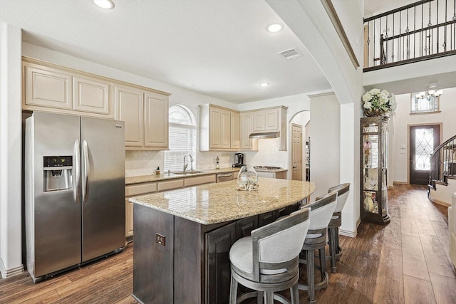 6015 Liverpool St, Celina, TX 76227 - kitchen with stainless steel fridge, cream cabinets, a sink, dark wood-type flooring, and arched walkways