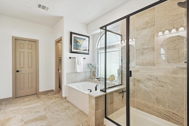 bathroom with visible vents, baseboards, a garden tub, and a shower stall