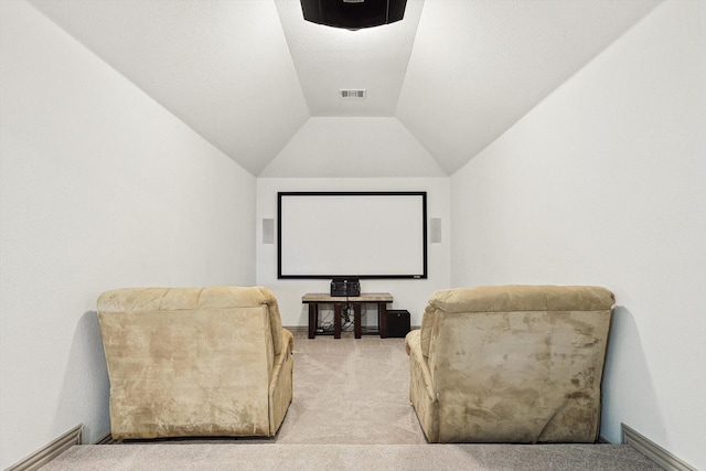 home theater room with visible vents, light carpet, and vaulted ceiling