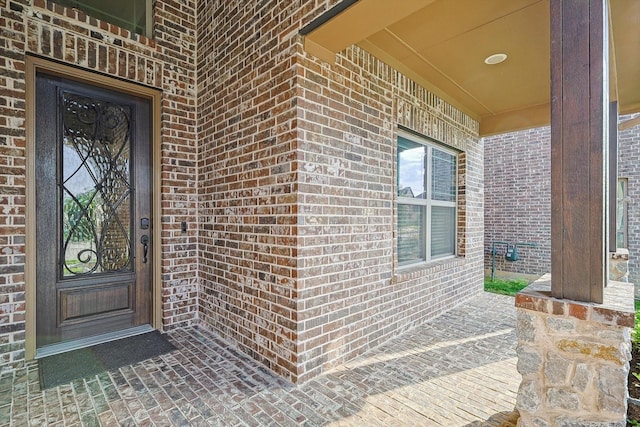 doorway to property featuring brick siding