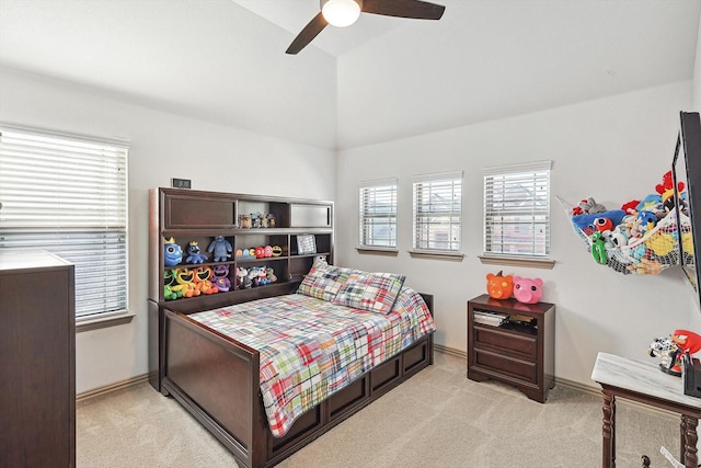 bedroom featuring light colored carpet, a ceiling fan, baseboards, and vaulted ceiling