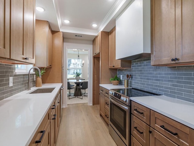 kitchen featuring visible vents, a sink, a tray ceiling, stainless steel appliances, and crown molding