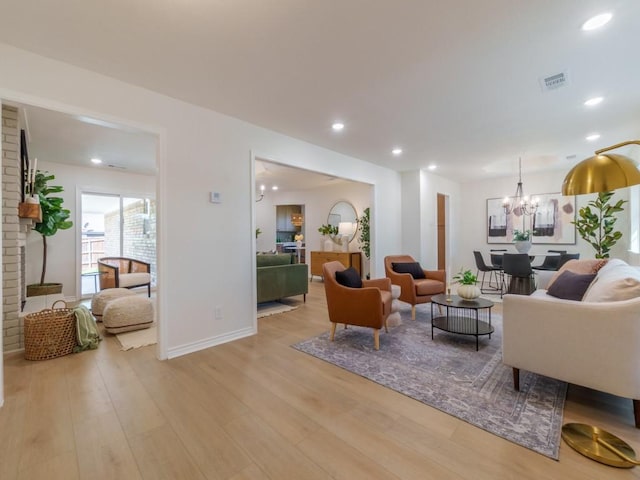 living room with baseboards, visible vents, an inviting chandelier, recessed lighting, and light wood-type flooring