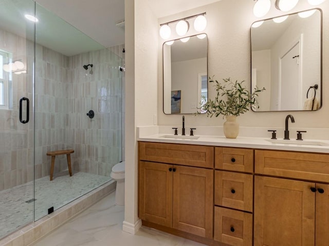 bathroom with marble finish floor, a stall shower, toilet, and a sink