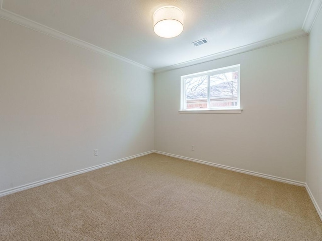 empty room with visible vents, baseboards, carpet, and crown molding