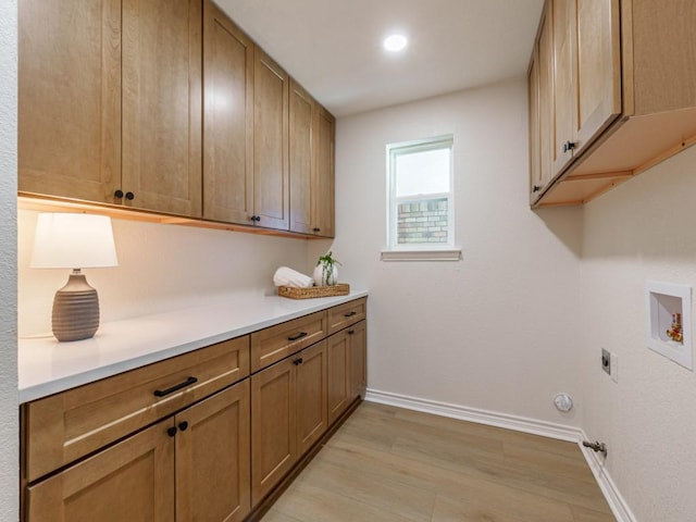 laundry area with electric dryer hookup, cabinet space, light wood-style floors, baseboards, and hookup for a washing machine