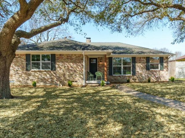 single story home with a shingled roof, a front lawn, brick siding, and a chimney