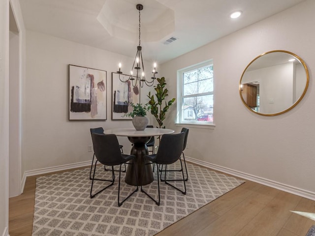 dining room with a notable chandelier, light wood-style floors, visible vents, and baseboards