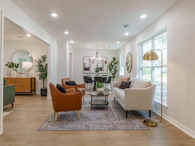 living area with recessed lighting, visible vents, a notable chandelier, and light wood finished floors