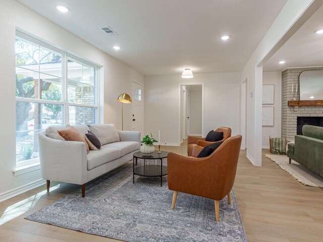 living room with recessed lighting, visible vents, baseboards, and light wood-style floors