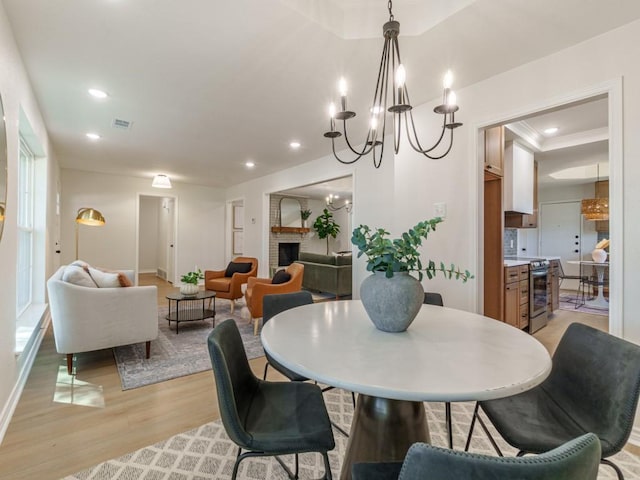 dining space with recessed lighting, visible vents, a notable chandelier, and light wood-style flooring