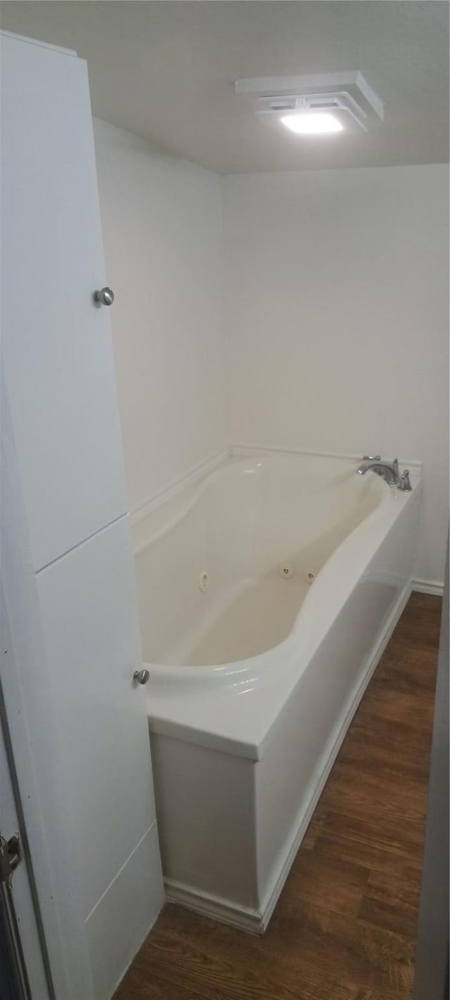 bathroom featuring wood finished floors and a whirlpool tub