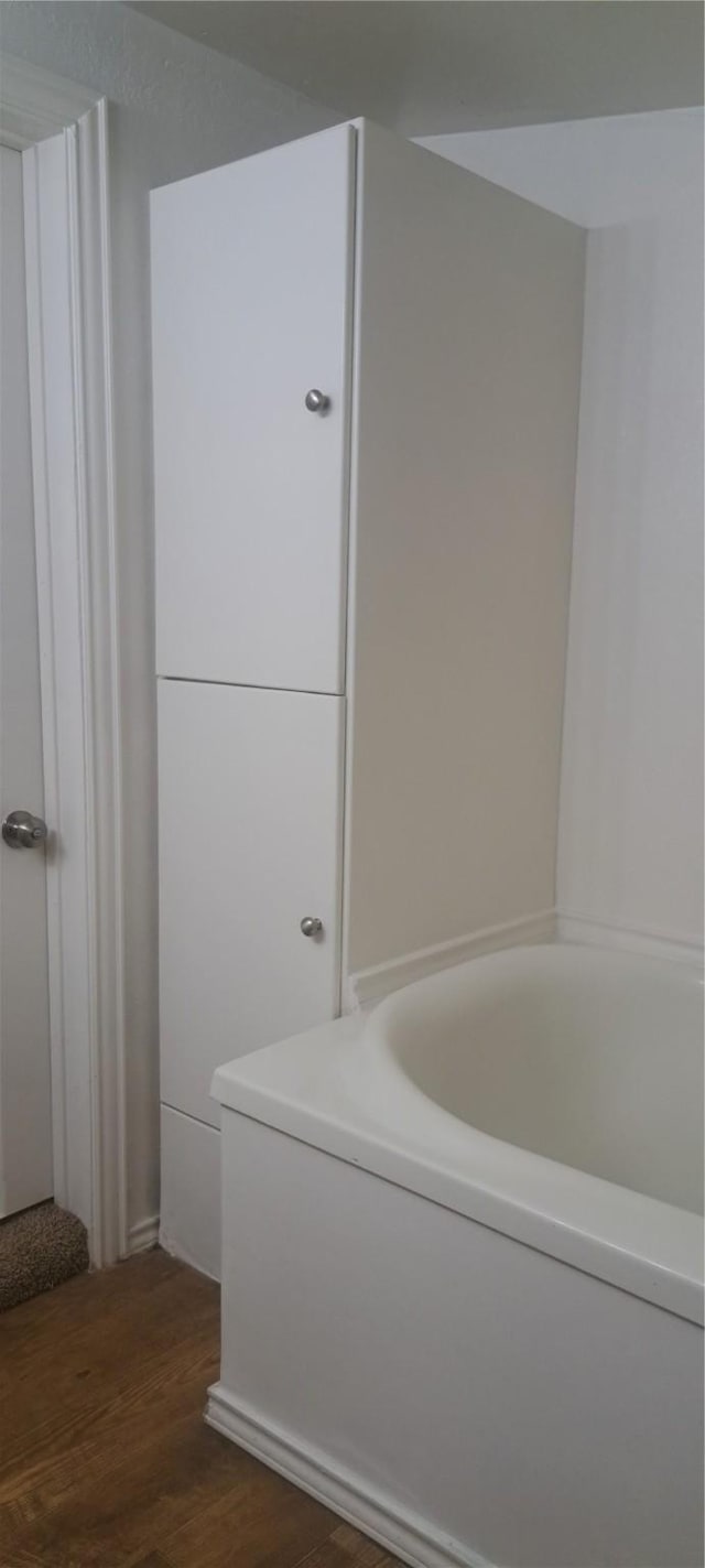 bathroom featuring a bath and wood finished floors