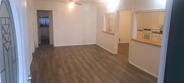 hallway featuring dark wood-type flooring and baseboards