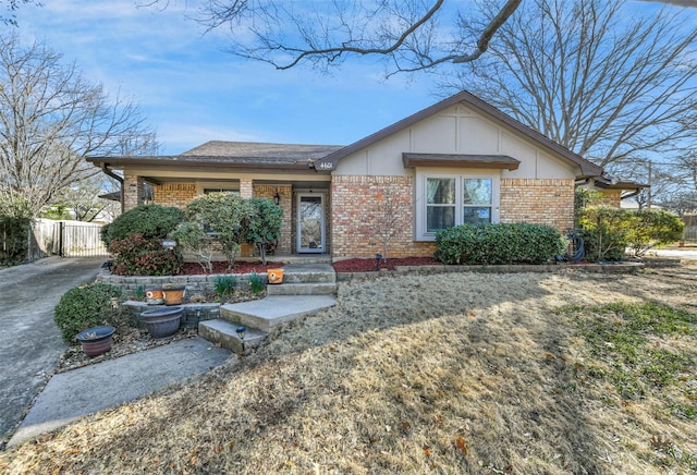 ranch-style home featuring brick siding and fence