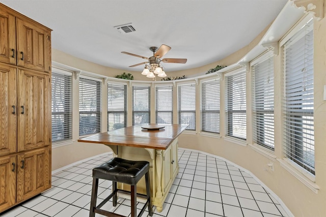 dining area featuring light tile patterned floors, visible vents, a healthy amount of sunlight, and ceiling fan