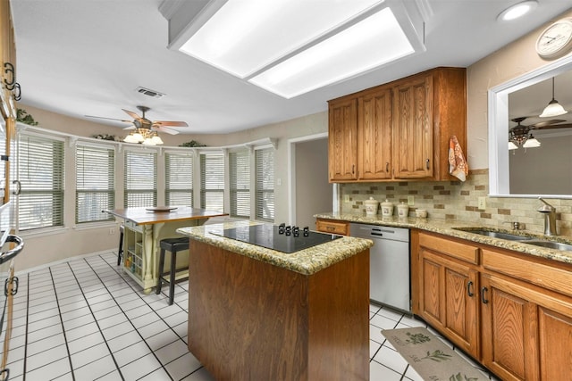 kitchen with light tile patterned floors, ceiling fan, a sink, stainless steel dishwasher, and black electric cooktop