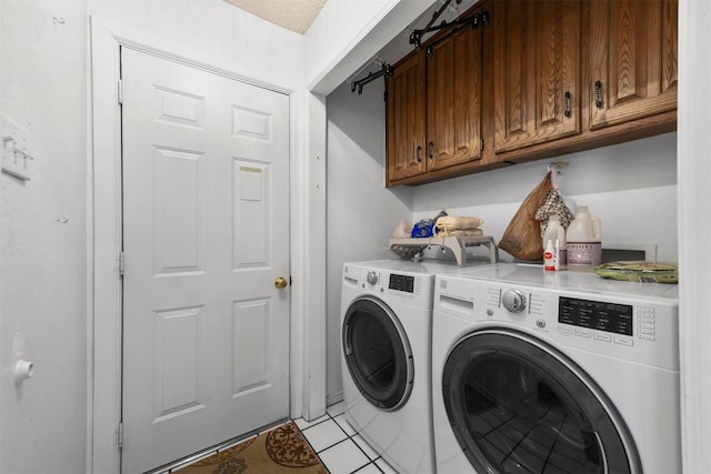 laundry room with washer and clothes dryer, cabinet space, and light tile patterned flooring