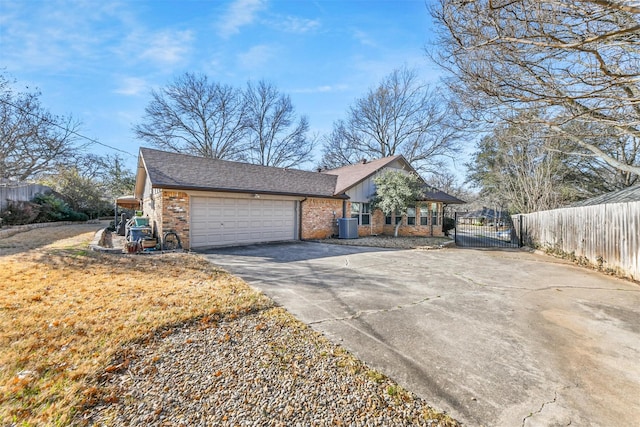 view of front of property with brick siding, driveway, an attached garage, and fence