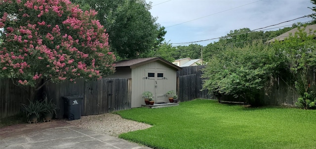 view of yard featuring an outdoor structure, a storage shed, and a fenced backyard