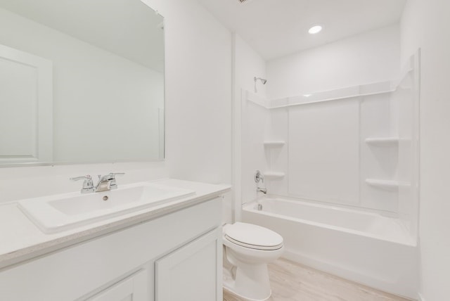 full bathroom with vanity, wood finished floors, toilet, and bathtub / shower combination