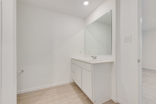 bathroom featuring recessed lighting, baseboards, wood finished floors, and vanity