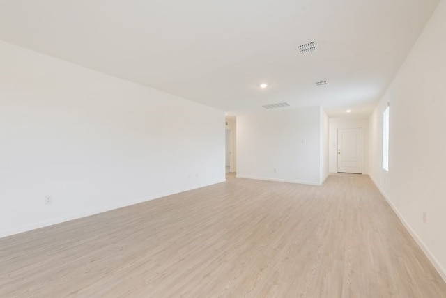 unfurnished room featuring visible vents, light wood-type flooring, and baseboards