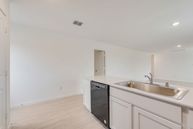 kitchen featuring light wood finished floors, visible vents, dishwasher, white cabinetry, and a sink