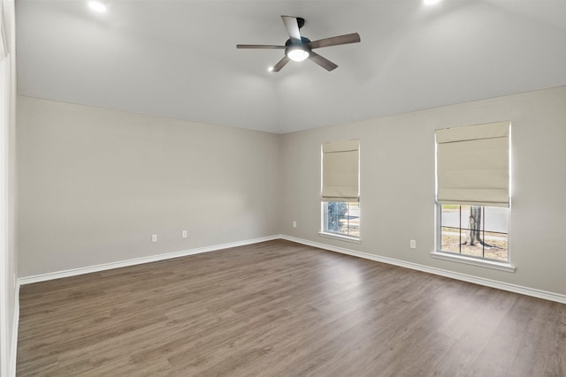 empty room featuring vaulted ceiling, baseboards, ceiling fan, and wood finished floors