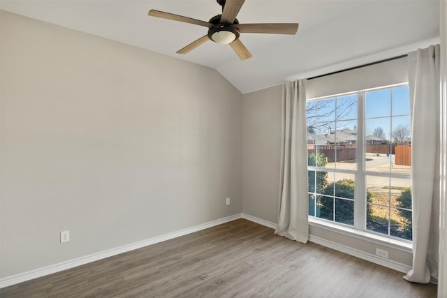 unfurnished room with a wealth of natural light, ceiling fan, baseboards, and wood finished floors