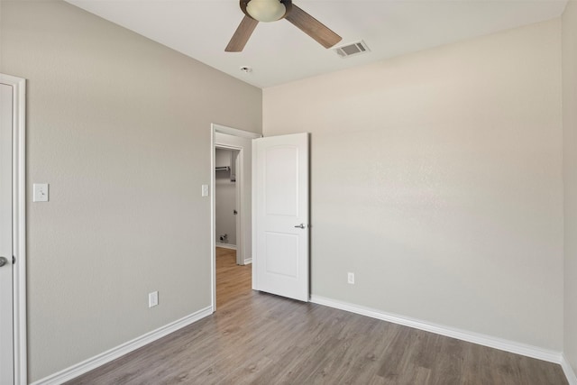 unfurnished bedroom featuring wood finished floors, visible vents, and baseboards