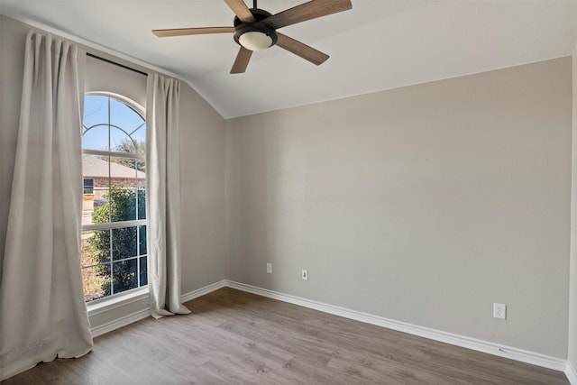 spare room featuring ceiling fan, baseboards, lofted ceiling, and wood finished floors