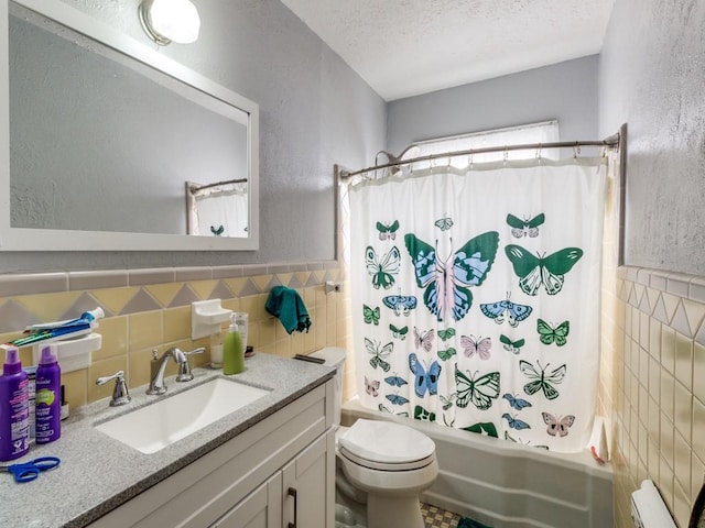 full bathroom featuring vanity, a textured ceiling, tile walls, and shower / bathtub combination with curtain