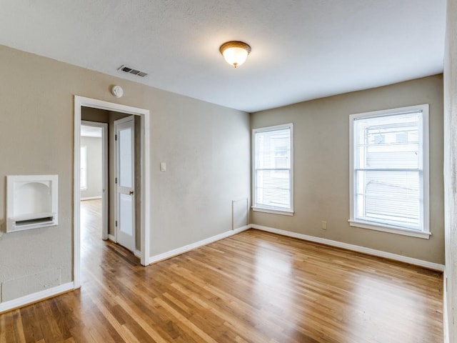 spare room with visible vents, baseboards, and light wood-style floors