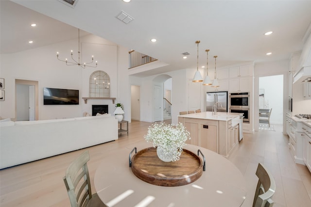 dining area featuring visible vents, an inviting chandelier, recessed lighting, a fireplace, and arched walkways