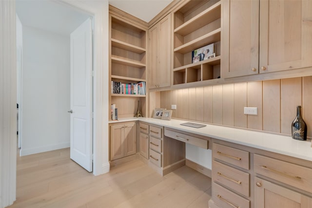 office space with light wood-type flooring and built in desk