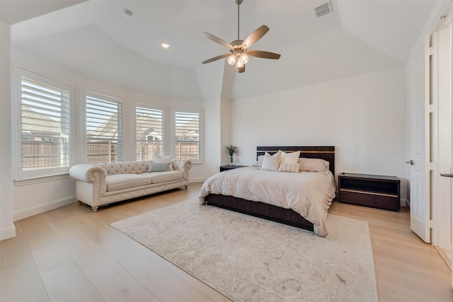 bedroom featuring lofted ceiling, light wood-style flooring, multiple windows, and visible vents