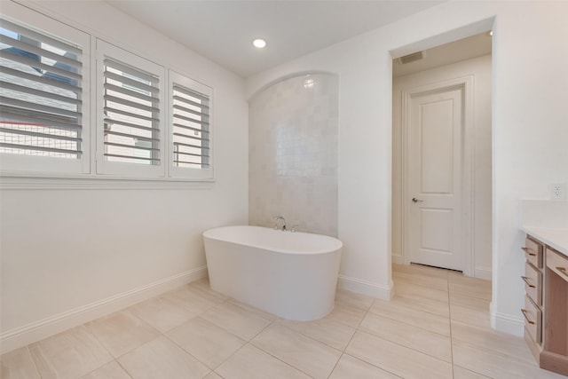 full bath featuring visible vents, baseboards, a freestanding tub, tile patterned floors, and vanity