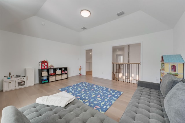 rec room with visible vents, lofted ceiling, and wood finished floors