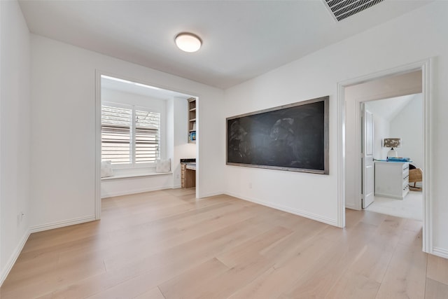 unfurnished living room with baseboards, visible vents, and light wood finished floors