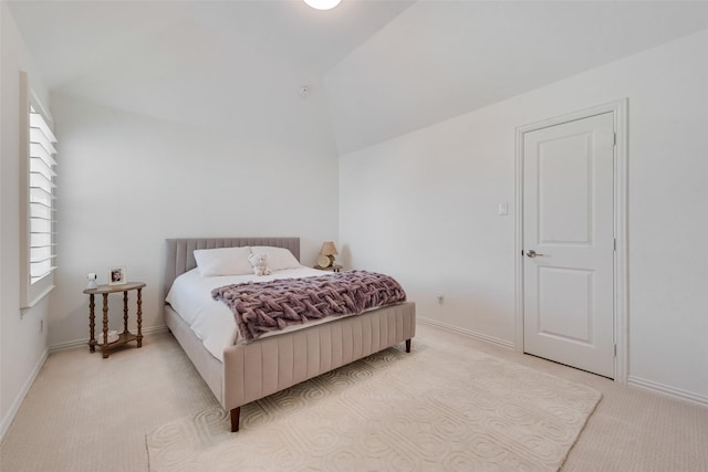 bedroom featuring light carpet, baseboards, and vaulted ceiling