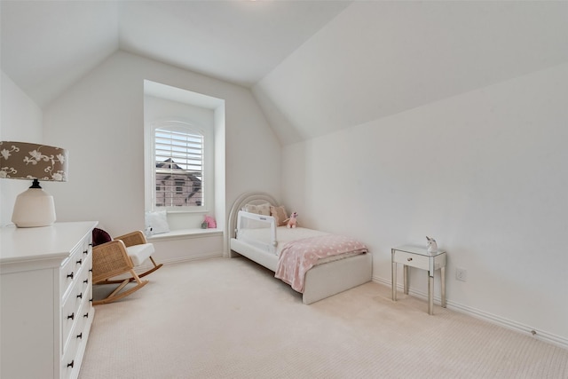 bedroom with lofted ceiling, baseboards, and light carpet