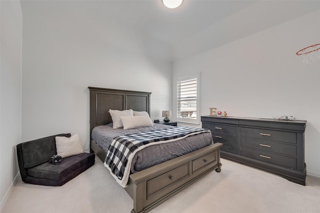 bedroom with light colored carpet and baseboards