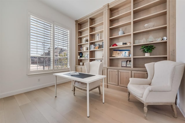 office space with baseboards and light wood-type flooring